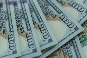 Many hundred dollar bills new banknotes in big pile under the natural light