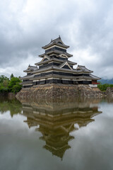 Fototapeta premium Historic Matsumoto Castle reflected in calm waters, Japan