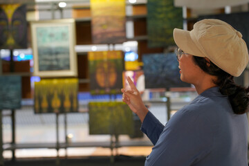 Woman observing artwork in modern art gallery. Captures moment of thoughtful appreciation, ideal for themes of creativity, inspiration, education, and cultural exploration.