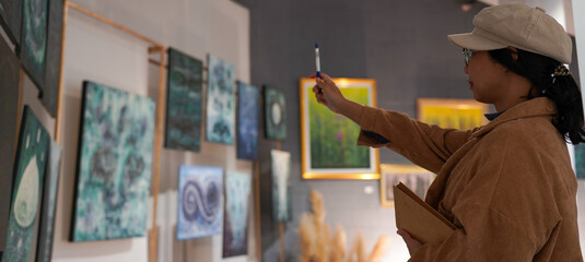 Woman observing artwork in modern art gallery. Captures moment of thoughtful appreciation, ideal for themes of creativity, inspiration, education, and cultural exploration.