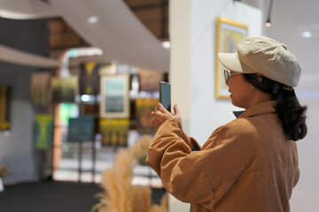 Woman observing artwork in modern art gallery. Captures moment of thoughtful appreciation, ideal for themes of creativity, inspiration, education, and cultural exploration.