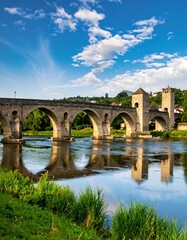 Obraz premium Ancient stone bridge over calm river