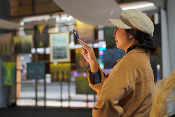 Woman observing artwork in modern art gallery. Captures moment of thoughtful appreciation, ideal for themes of creativity, inspiration, education, and cultural exploration.