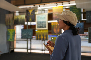 Woman observing artwork in modern art gallery. Captures moment of thoughtful appreciation, ideal for themes of creativity, inspiration, education, and cultural exploration.