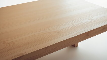 A close-up of a light-colored wooden table with a smooth surface and visible wood grain.