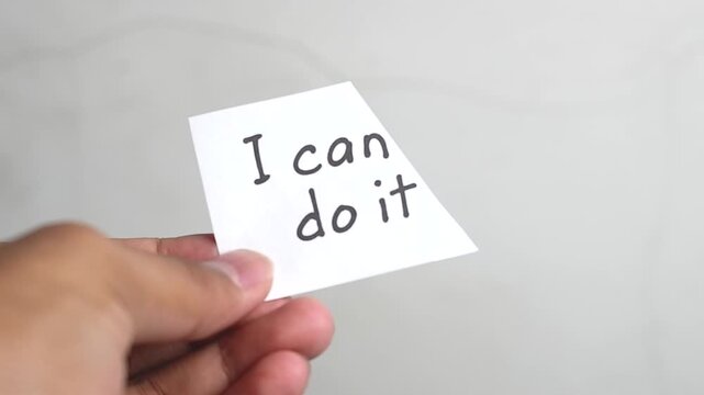Man using scissors to remove the word can't to read I can do it concept for self belief, positive attitude and motivation