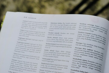 Obraz premium A close-up of an open medical textbook, showing detailed text and diagrams about human physiology and biology. This image represents study, education, research, and the journey of a medical student.