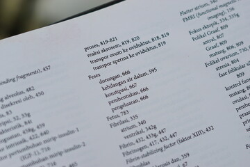 A close-up of an open medical textbook, showing detailed text and diagrams about human physiology and biology. This image represents study, education, research, and the journey of a medical student.