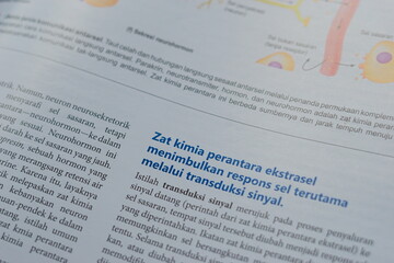 Obraz premium A close-up of an open medical textbook, showing detailed text and diagrams about human physiology and biology. This image represents study, education, research, and the journey of a medical student.