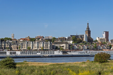 Fototapeta premium The cityscape of Nijmegen with a focus on the riverside buildings, the St. Stephen's Church, and cruise ships. Nijmegen, Netherlands. 20 June 2025.