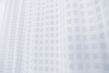 Subtle Elegance: A close-up view of delicate curtains, with soft light dancing across the textured surface, creating a sense of tranquility and gentle movement.