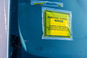 A yellow parking charge notice ticket was placed on the car windscreen, warning against...