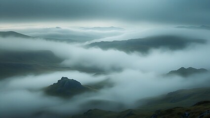 Misty mountain range shrouded in fog during sunrise, creating a serene and atmospheric landscape