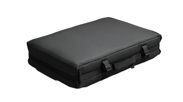 Bouldering crash pad folded in half with compression straps buckled and tidy handles, reinforced corners and matte fabric, isolated on transparent background.
