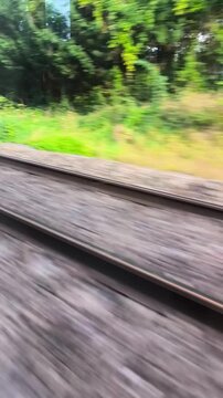 Vertical 4K shot: railway tracks from moving train, Paris suburbs.