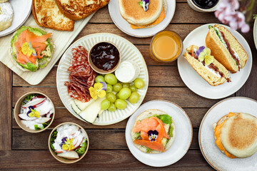 brunch sur table brioche perdues toast, muffins, pancakes, fruits charcuteries, jus de fruit et café