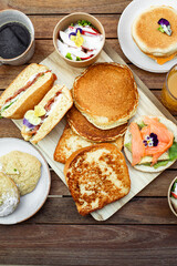 brunch sur table brioche perdues toast, muffins, pancakes, fruits charcuteries, jus de fruit et café