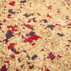 Macro close-up of a cork sheet with natural beige and red inclusions. Eco-friendly surface texture for design and decoration.