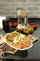 Traditional Turkish Doner Kebab Plate with Fresh Vegetables, French Fries, and Sauces on Rustic Background