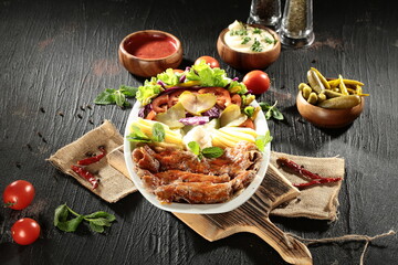 Traditional Turkish Doner Kebab Plate with Fresh Vegetables, French Fries, and Sauces on Rustic Background
