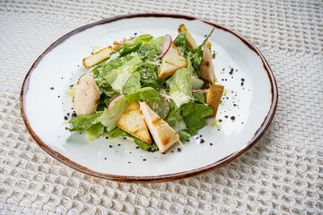 fresh salad with grilled cheese in a white plate on a white background