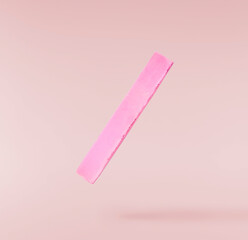 Back to school conception. Flying in the air school equipment. A chalk levitating in the air isolated on pink background