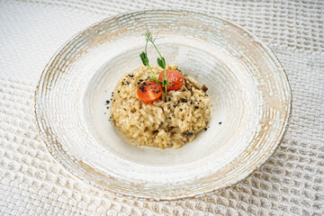 Bulgur porridge decorated with microgreens in a white plate on a white background
