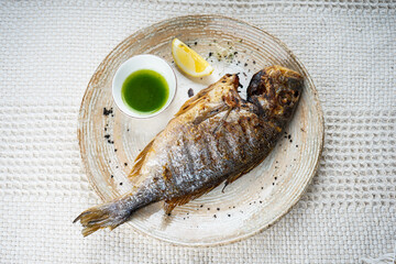 
whole baked fish with head on a white plate
