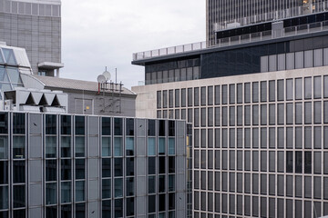 Cluster of modern office buildings with grid facades and contemporary architecture, designed as financial headquarters, corporate banking identity, and economic business architectural imagery.