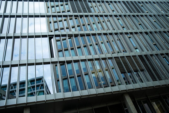 Modern office architecture with reflective glass facades and abstract design, symbolizing corporate finance, economy, and investment opportunities, ideal for professional financial backgrounds.