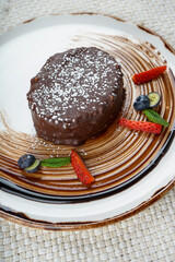 dessert chocolate cake decorated with mint and strawberries in a plate