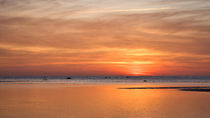 Fototapeta premium Sunset over the sea, golden light reflections and silent expanse