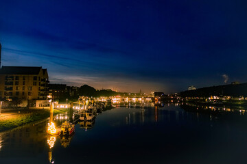 Nighttime river view with lights and buildings creating a tranquil urban atmosphere, looking south over the Weser River at dawn, Stephanibrücke 28199 Bremen