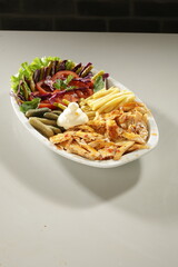 Traditional Turkish Chicken Doner Kebab Plate with French Fries, Pickles and Fresh Vegetables on white background
