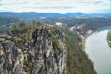 Majestic rock formation overlooking a river and a village in the valley.