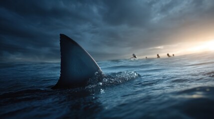 Fototapeta premium Shark fin emerges menacingly from dark ocean water with blurry figures of men in the distance illustrating danger.