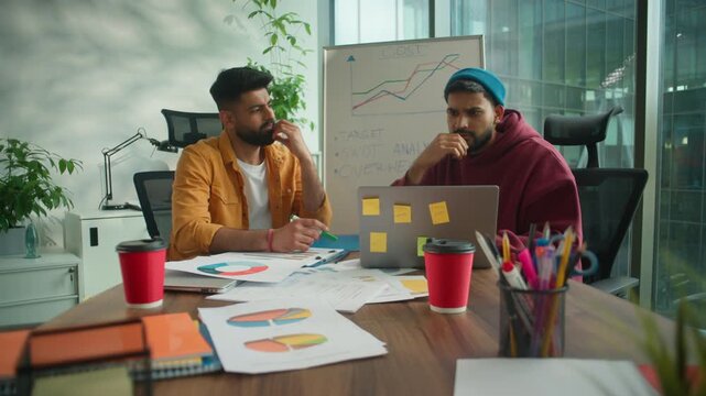 Pensive thinking two Arabian guys males Hindu business men with laptop think solution come up with idea decision online insight in informal office startup managers Indian businessmen brainstorming