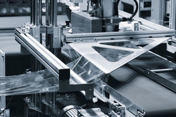 Automatic industrial machine for producing polyethylene bags or packaging products in plastic film. Automatic packaging of products and food products concept.