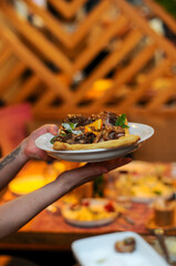 dish on a plate in the hands of a waitress