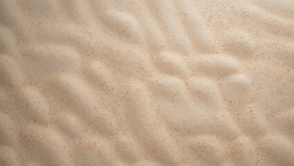 A close-up of smooth, textured sand with gentle ripples on a beach surface.