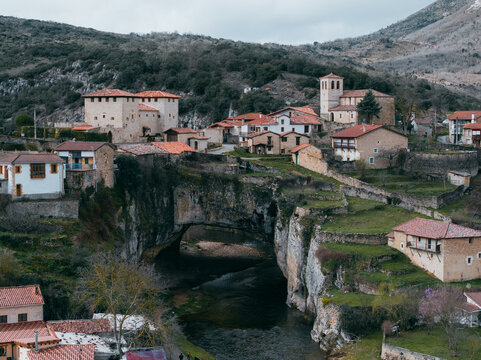 Aerial view of the village nestled atop a natural bridge, a stone tapestry woven between the mountains and the river below, Puentedey, Castile and Le&Atilde;&sup3;n, Spain.