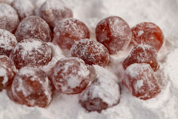dried kumquat and powdered white sugar, sweet dried orange kumquat fruits in white powdered sugar