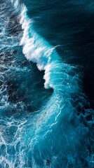 Fototapeta premium Aerial view of a powerful ocean wave crashing on a sunny day at the sea