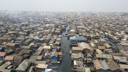 Aerial view of wooden homes clustered densely along waterways, creating a textured tapestry of urban life and resilience, Makoko, Lagos, Nigeria.