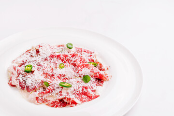 Gourmet beef carpaccio with fresh herbs and peppers served on a plate