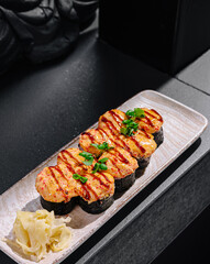 Delicious sushi rolls with grilled topping served on a sleek platter