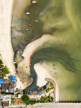 Aerial view of boats resting on the beach's edge, a vibrant contrast against the light sands and emerald waters, Hua Hin, Prachuap Khiri Khan, Thailand.