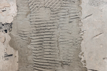 Fresh cement plaster with trowel marks on wall under renovation