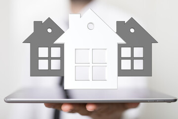 Image of a real estate agent showcasing digital house models on a tablet, symbolizing property search and home buying.