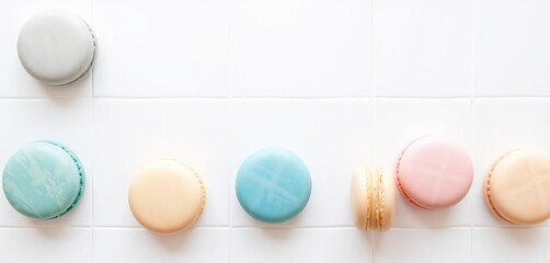 Obraz premium Pastel-colored French macarons arranged on a pristine white tile surface, delicious, french macaron